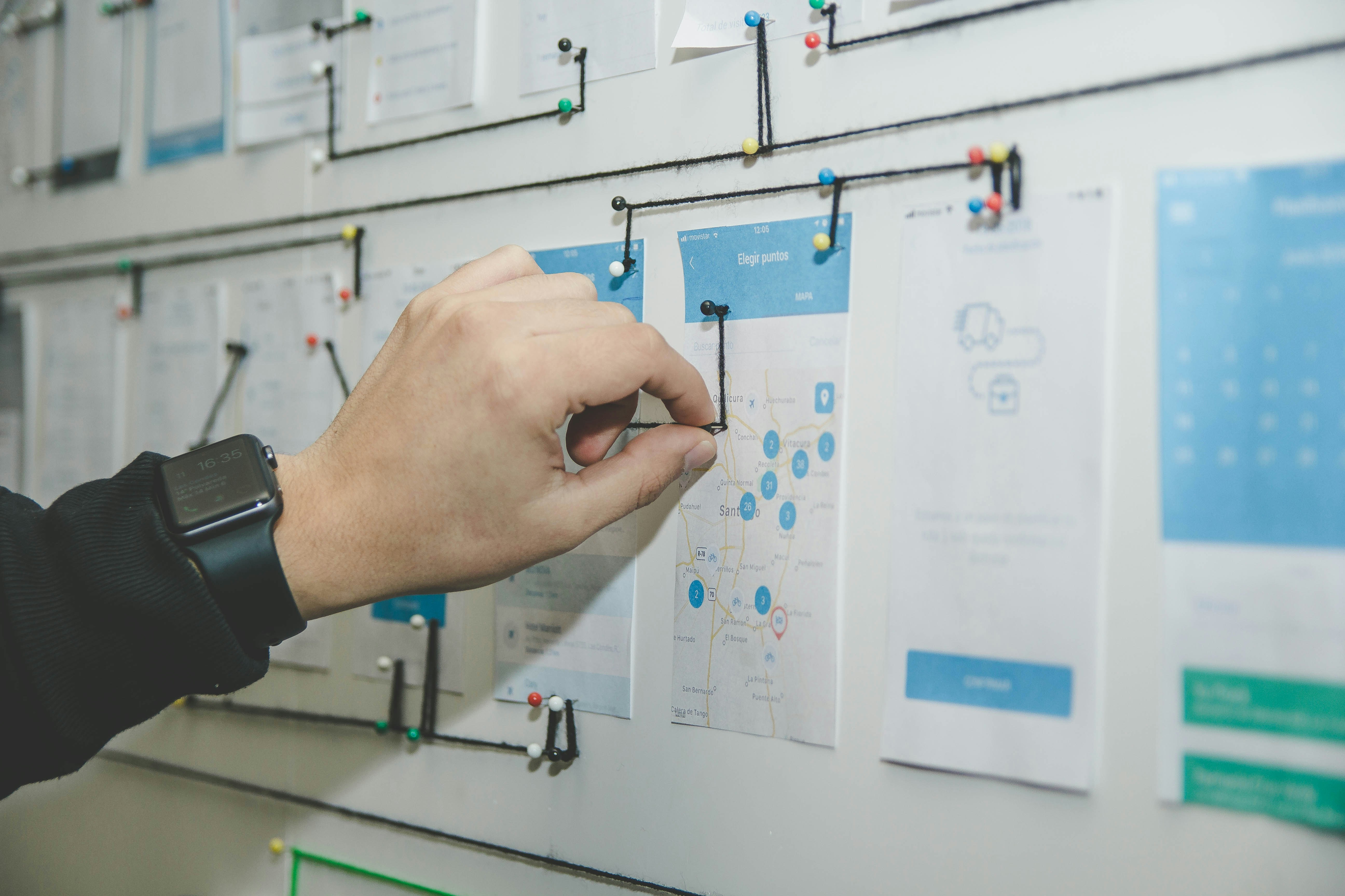 Man's hand connecting strategic notes on the wall